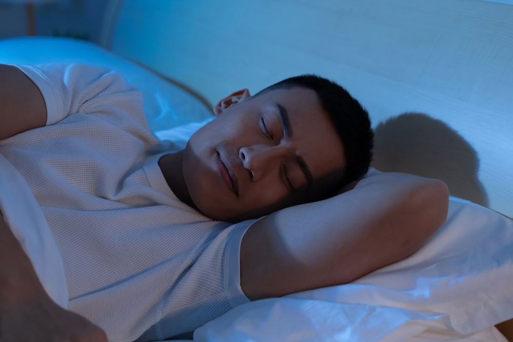 A man sleeping soundly, having taken indica or sativa for sleep beforehand.